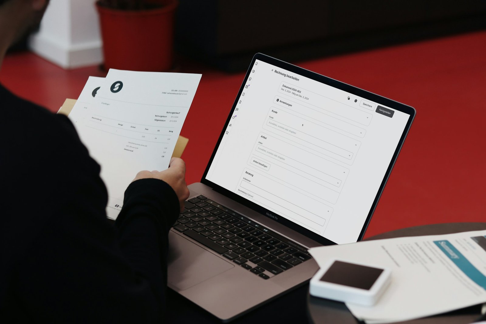 Printed commercial paperwork reviewed beside a laptop
